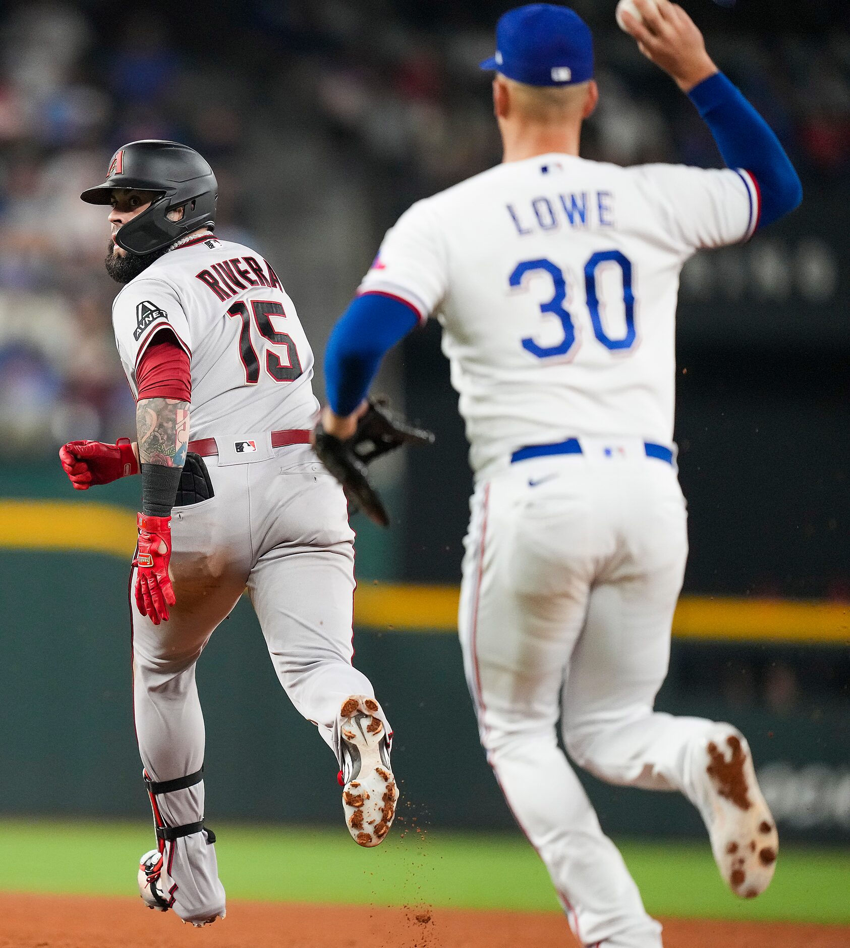 Arizona Diamondbacks' Emmanuel Rivera is caught in a rundown by Texas Rangers first baseman...