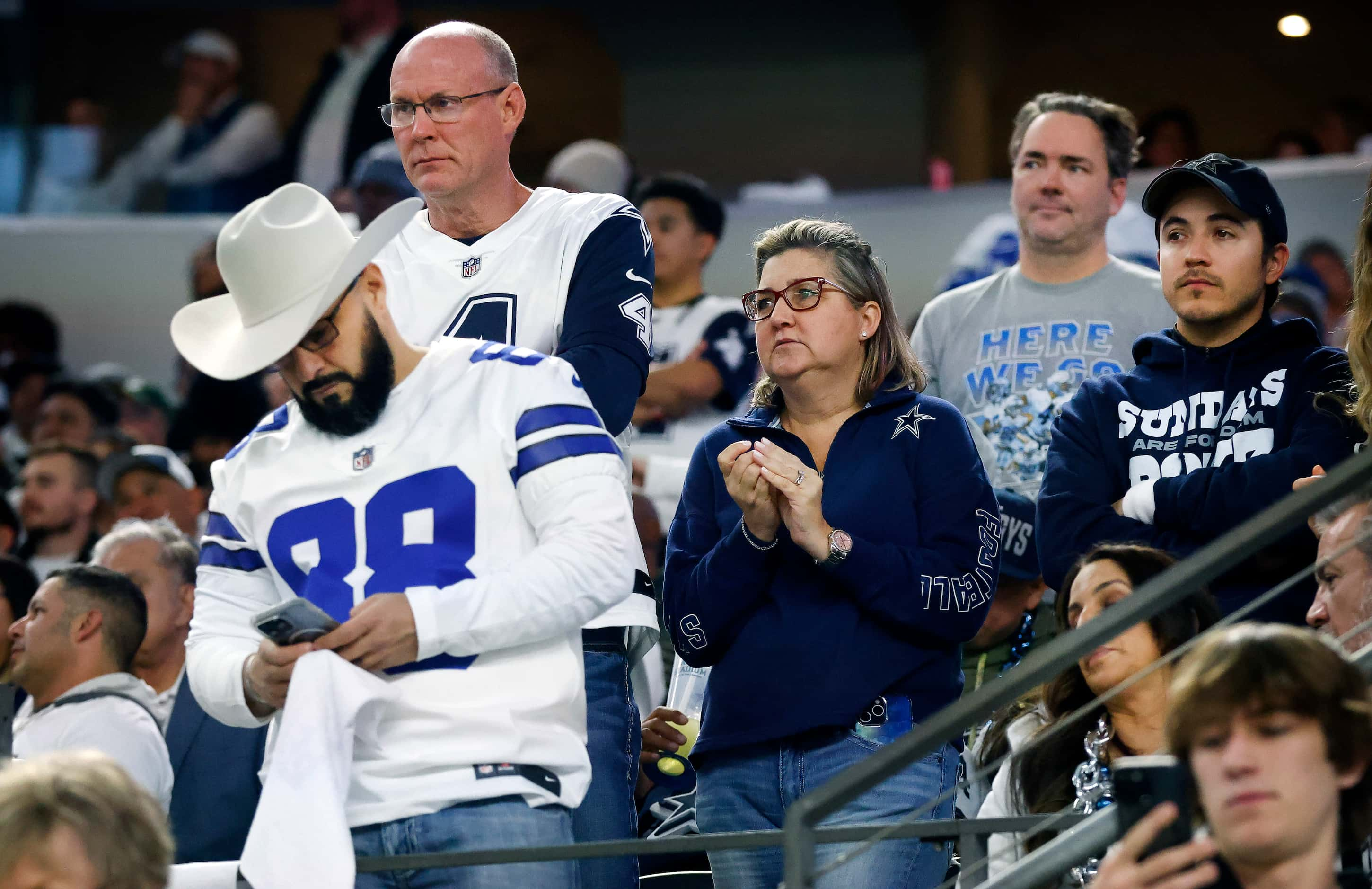 Dallas Cowboys fans watch as their team trials the Green Bay Packers during the first half...