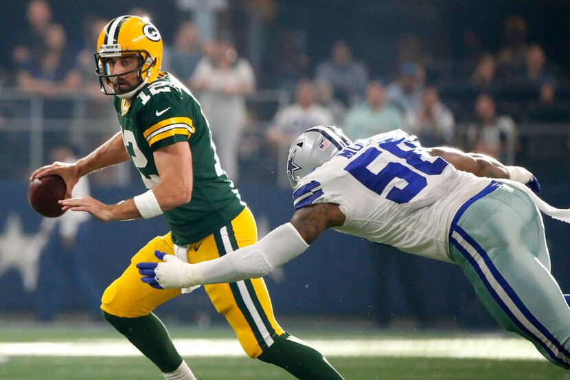 Green Bay Packers quarterback Aaron Rodgers (12) scrambles away from Dallas Cowboys...