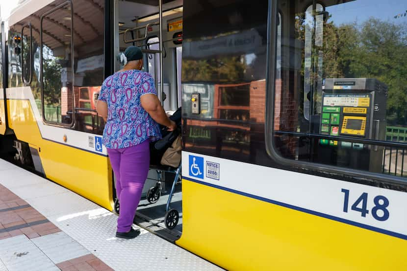 Phedeje Nwaneche of Dallas boards a DART light rail train at the downtown Plano Station,...