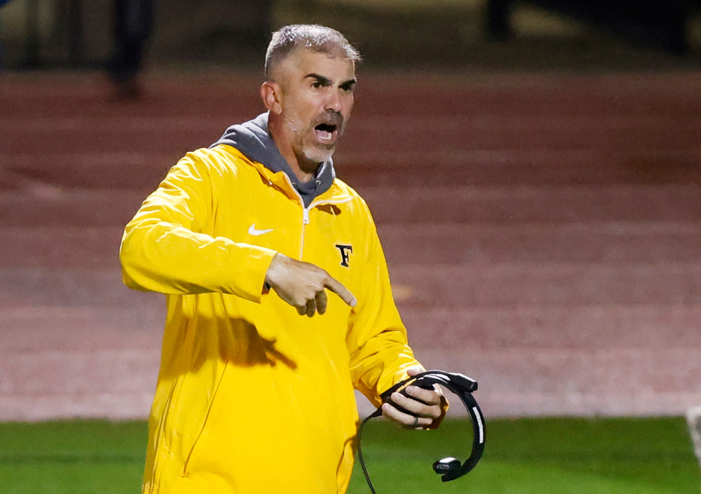 Forney head football coach Jeff Fleener yells to his players to line up for a two-point...