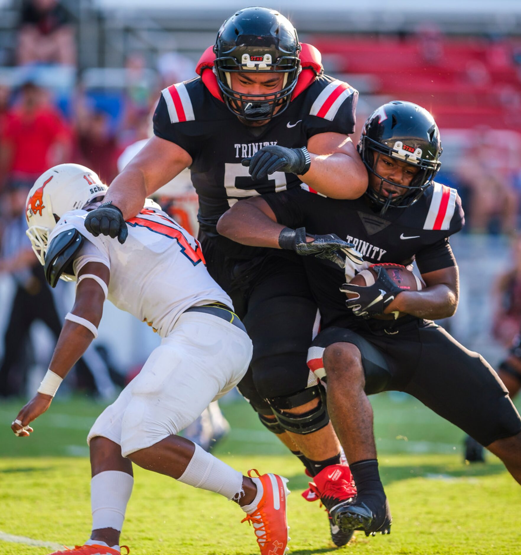 Euless Trinity running back AJ Barnett (5) rides the block from guard Penilotu Asaeli (51)...