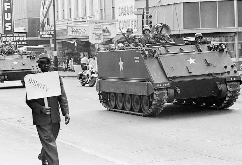 A striking Memphis sanitation worker carried a placard as the city's garbage and trash...