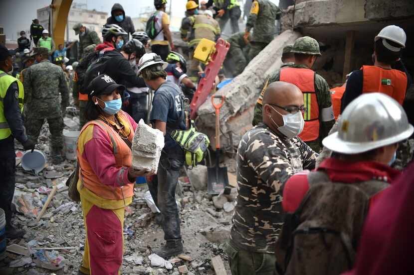 Volunteers removed rubble during the search for survivors in a flattened building in Mexico...