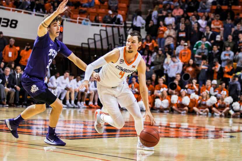 Oklahoma State's Thomas Dziagwa dribbles around TCU guard Francisco Farabello during an NCAA...