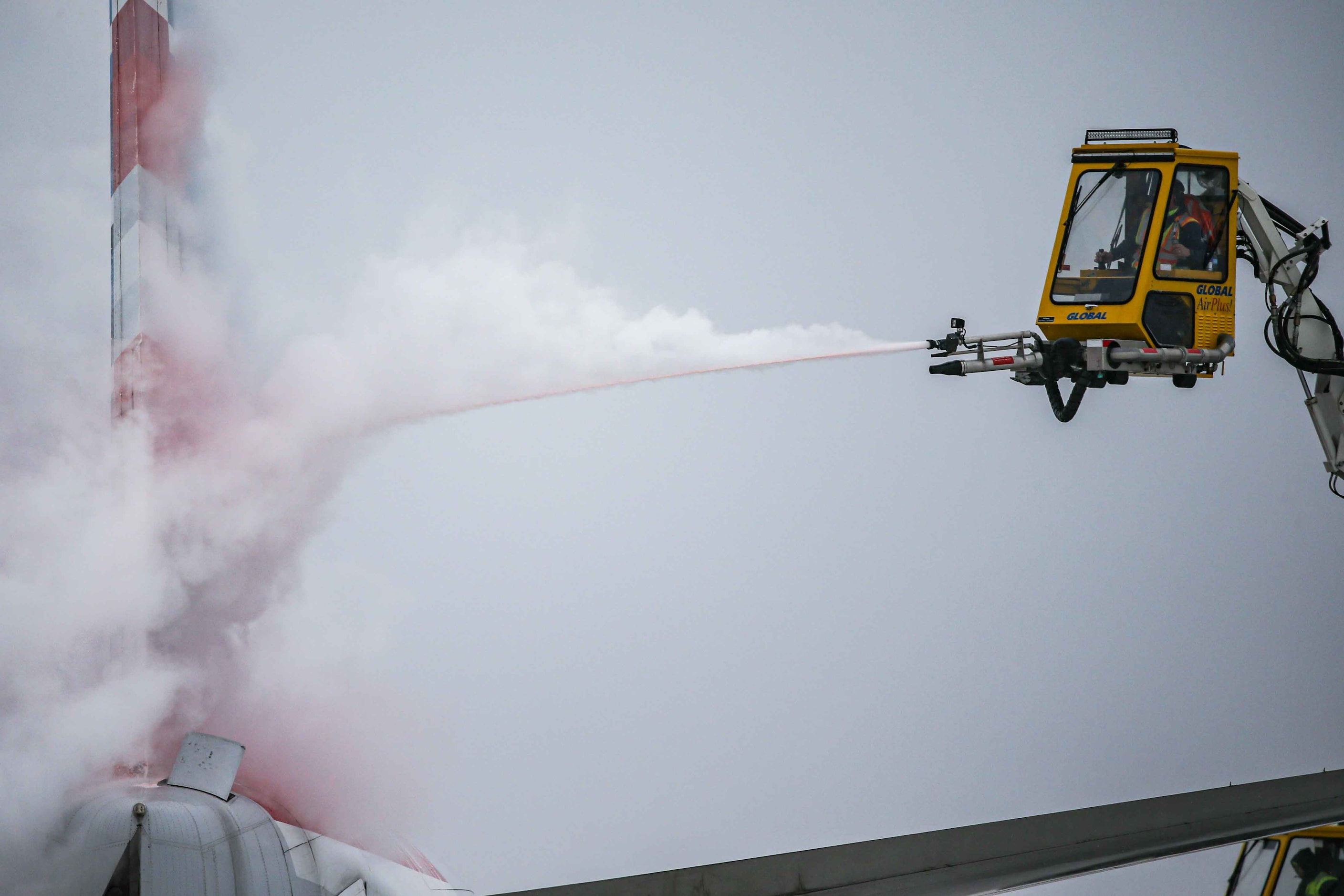 An American Airlines jet is de-iced at DFW International Airport before takeoff as winter...