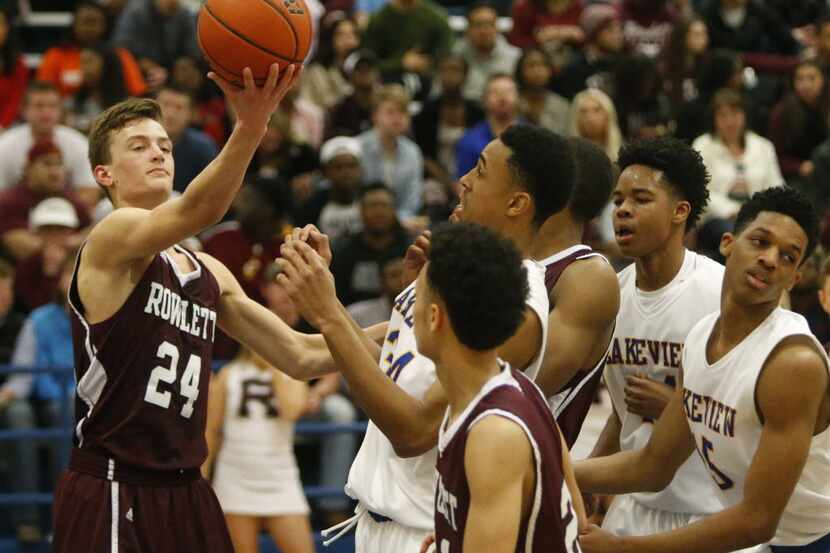 Rowlett's Evan Ghormley (24) grabs a rebound away from a cluster of players in the first...