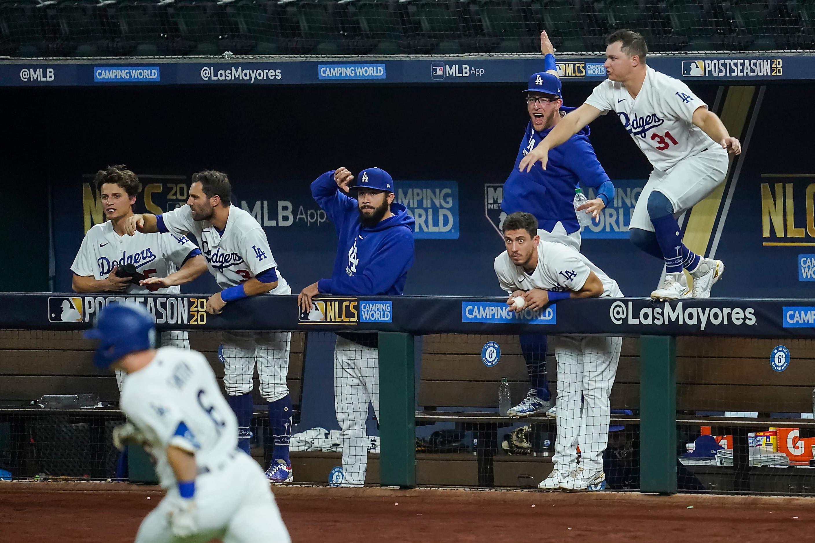 Players in the Los Angeles Dodgers dugout celebrate as catcher Will Smith (16) drives in two...