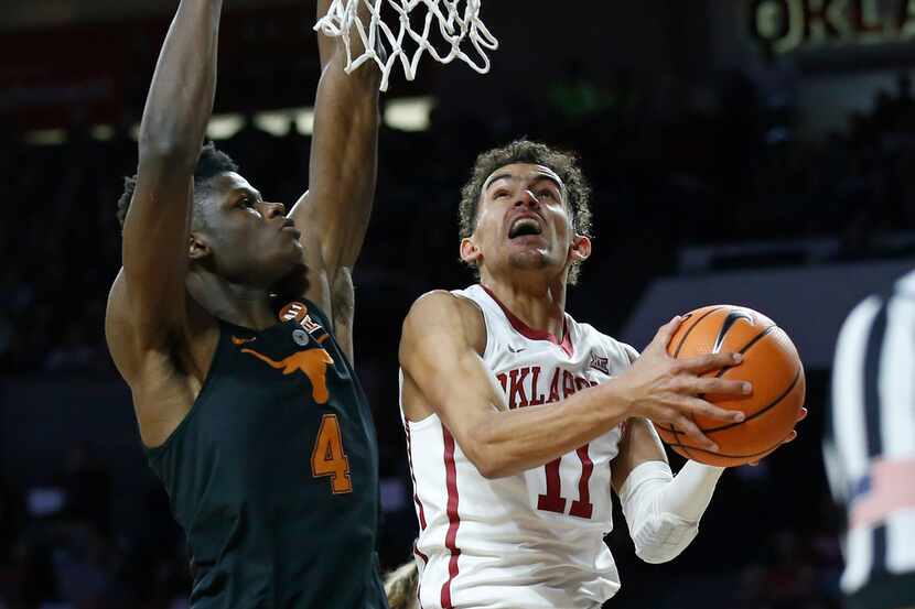 Oklahoma guard Trae Young (11) goes to the basket in front of Texas forward Mohamed Bamba...