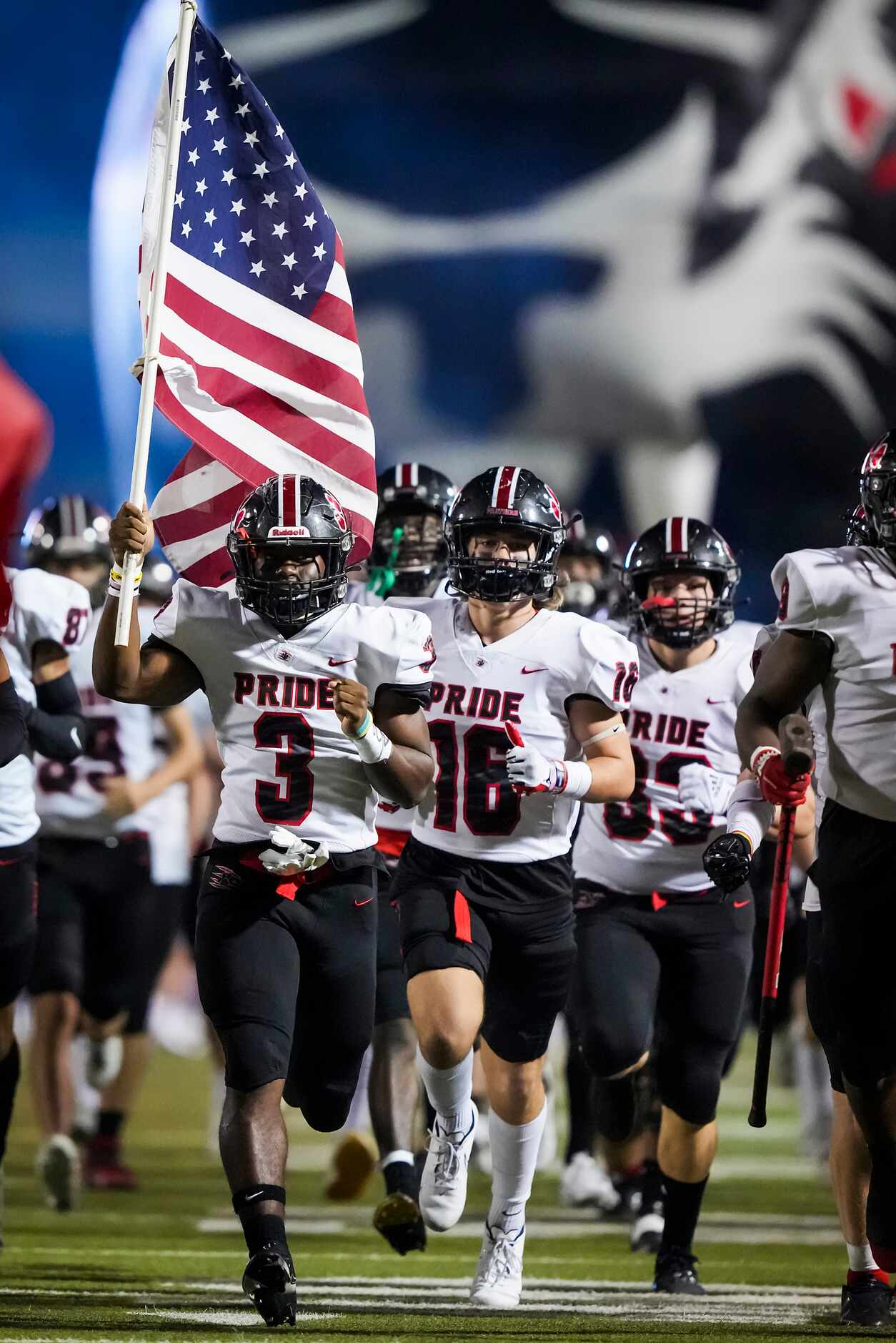 Colleyville Heritage running back Isaac Shabay (3) carries the stars and stripes as he leads...