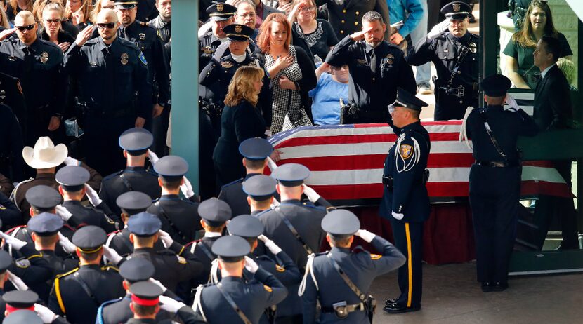 The casket of Little Elm police detective Jerry Walker is rolled from the funeral service to...