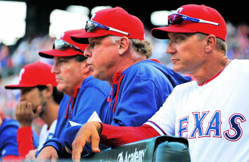 Texas Rangers manager Jeff Banister (28), right, watches the ninth inning with bench coach...
