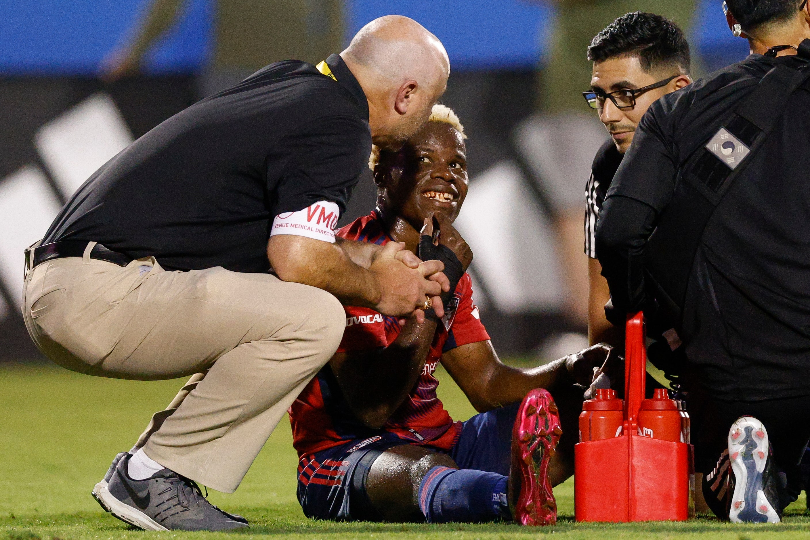 FC Dallas forward Bernard Kamungo (77) smiles as he shows an injury to his teeth to members...