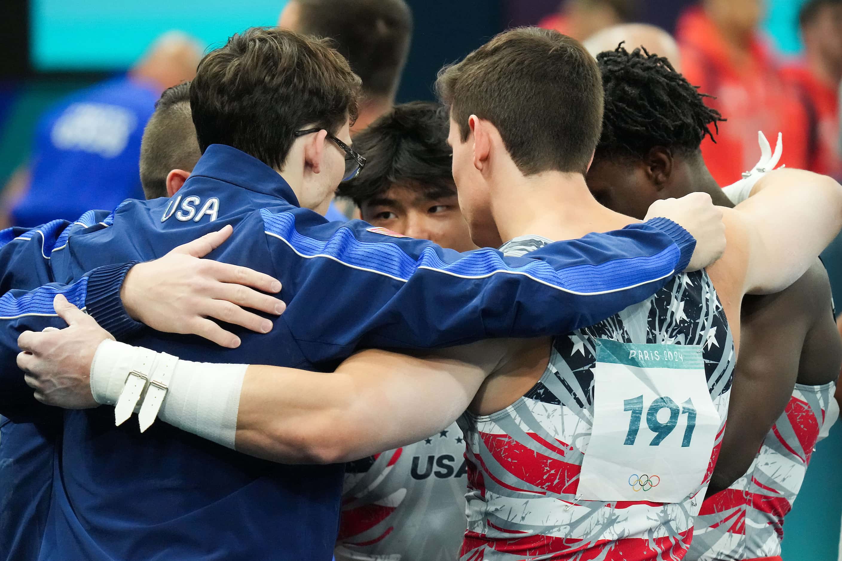 Asher Hong of the United States (center) huddles with teammates (from left) Paul Juda,...
