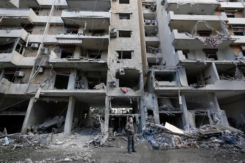 A man stands in front of a destroyed building after Sunday's Israeli airstrike in Dahiyeh,...