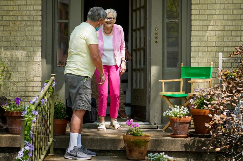 Vic Colon greets neighbor Jane Barker on her porch.