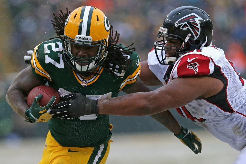 GREEN BAY, WI - DECEMBER 08: Eddie Lacy #27 of the Green Bay Packers is grabbed on a run by...