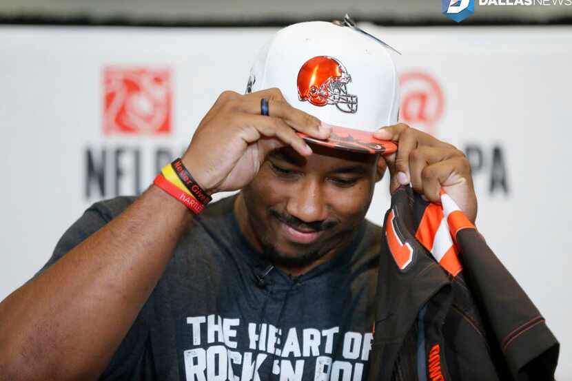 Myles Garrett of Texas A&M and Arlington Martin puts on a Cleveland Browns hat after being...