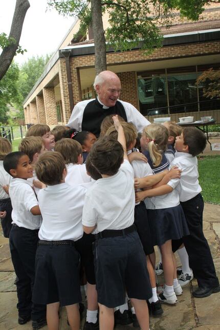 Father Swann is surrounded by students at the Episcopal School of Dallas in this undated...