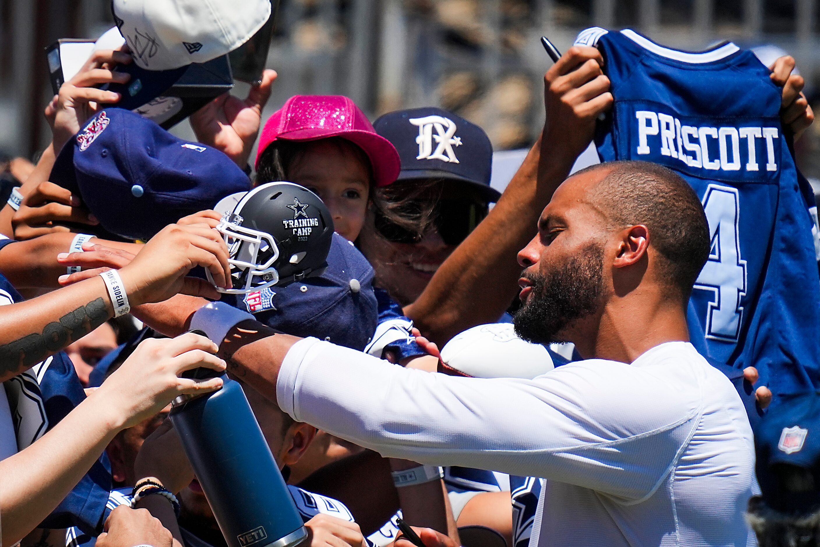 Dallas Cowboys quarterback Dak Prescott (4) signs autographs for fans following a training...