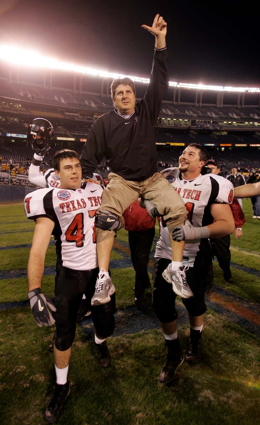 Texas Tech head coach Mike Leach is carried by Clay McGuire and Cody Campbell (right) after...