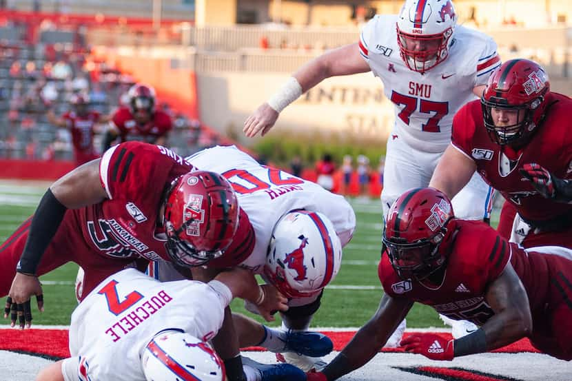 Arkansas State defensive end William Bradley King, upper left, sacks SMU quarterback Shane...