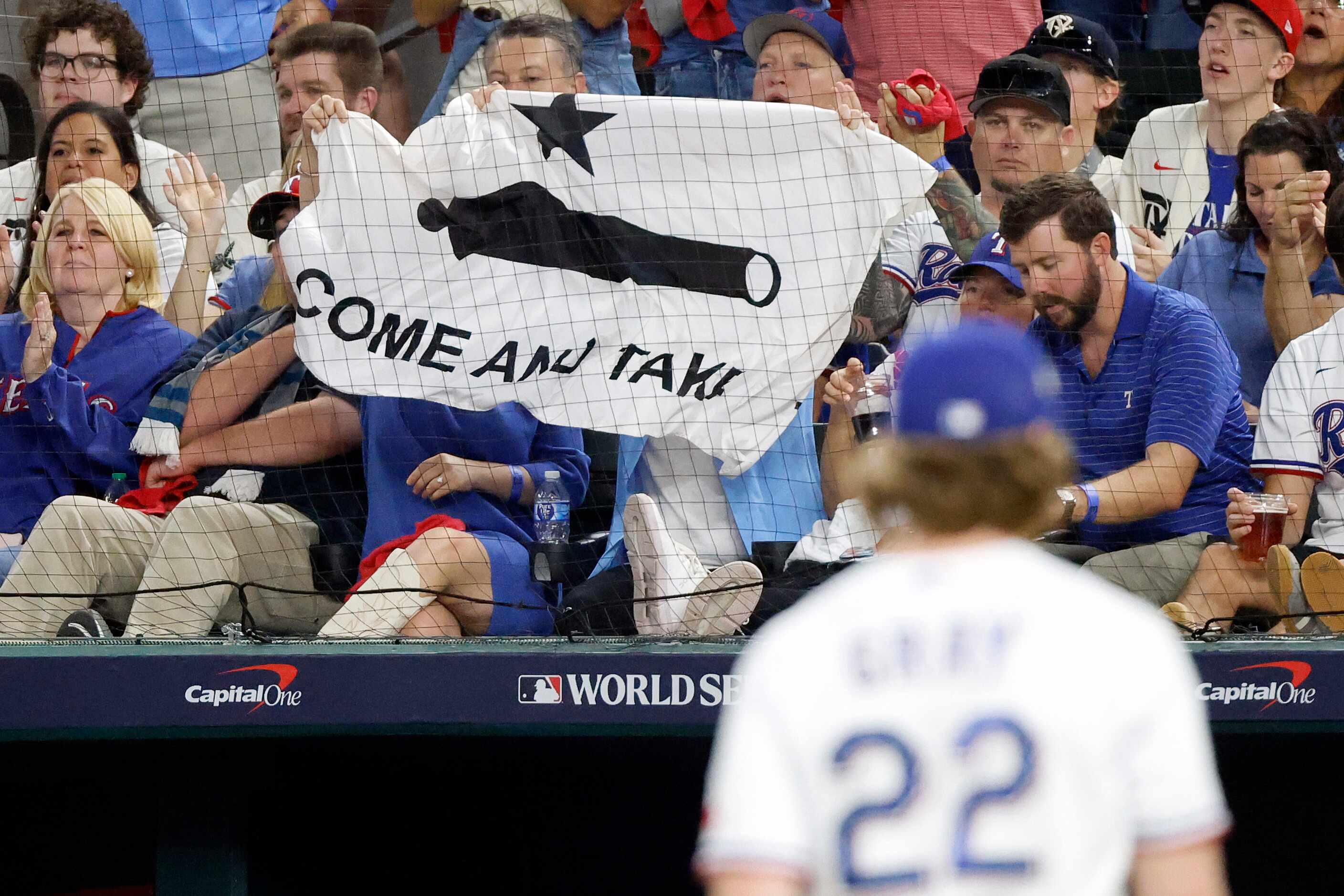 Texas Rangers fans wave a "Come and Take It" flag as pitcher Jon Gray walks to the dugout...