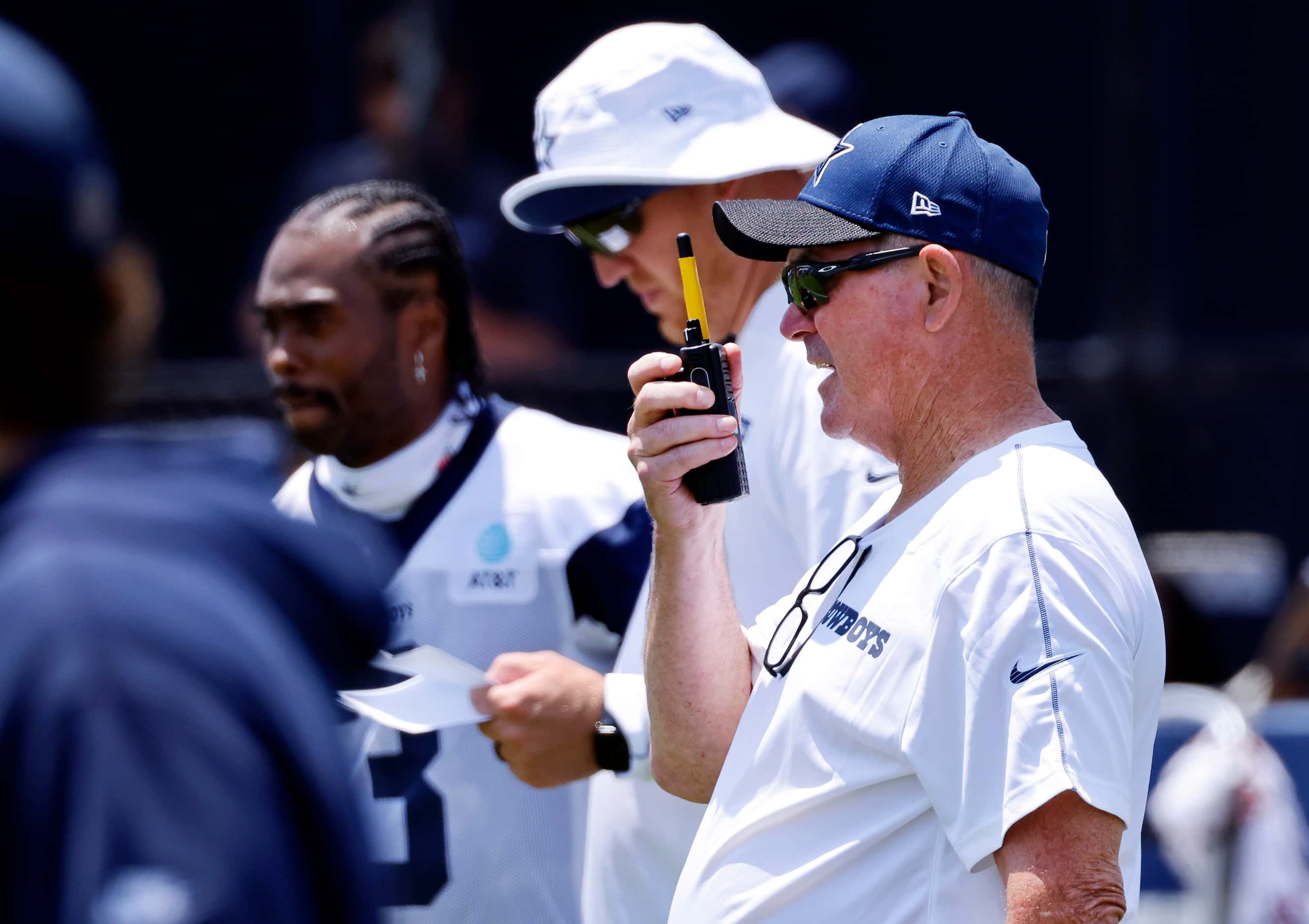 Dallas Cowboys defensive coordinator Mike Zimmer radios a call from the sideline during the...