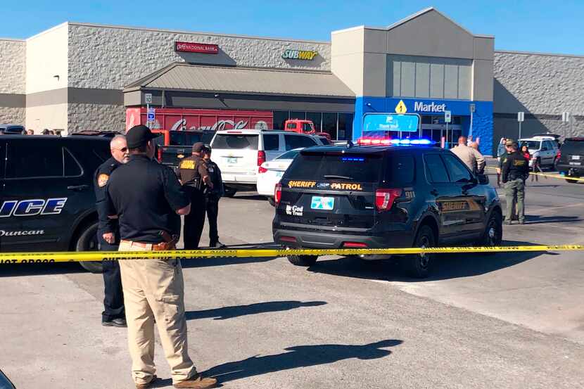 Law enforcement personnel investigate outside a Walmart where two men and a woman were...