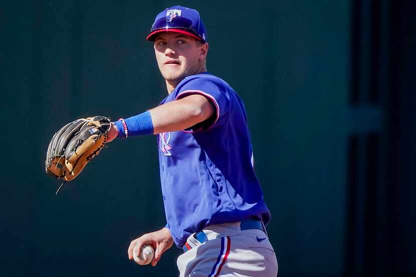 Texas Rangers infielder Josh Jung warms up at third base during the fifth inning of a spring...