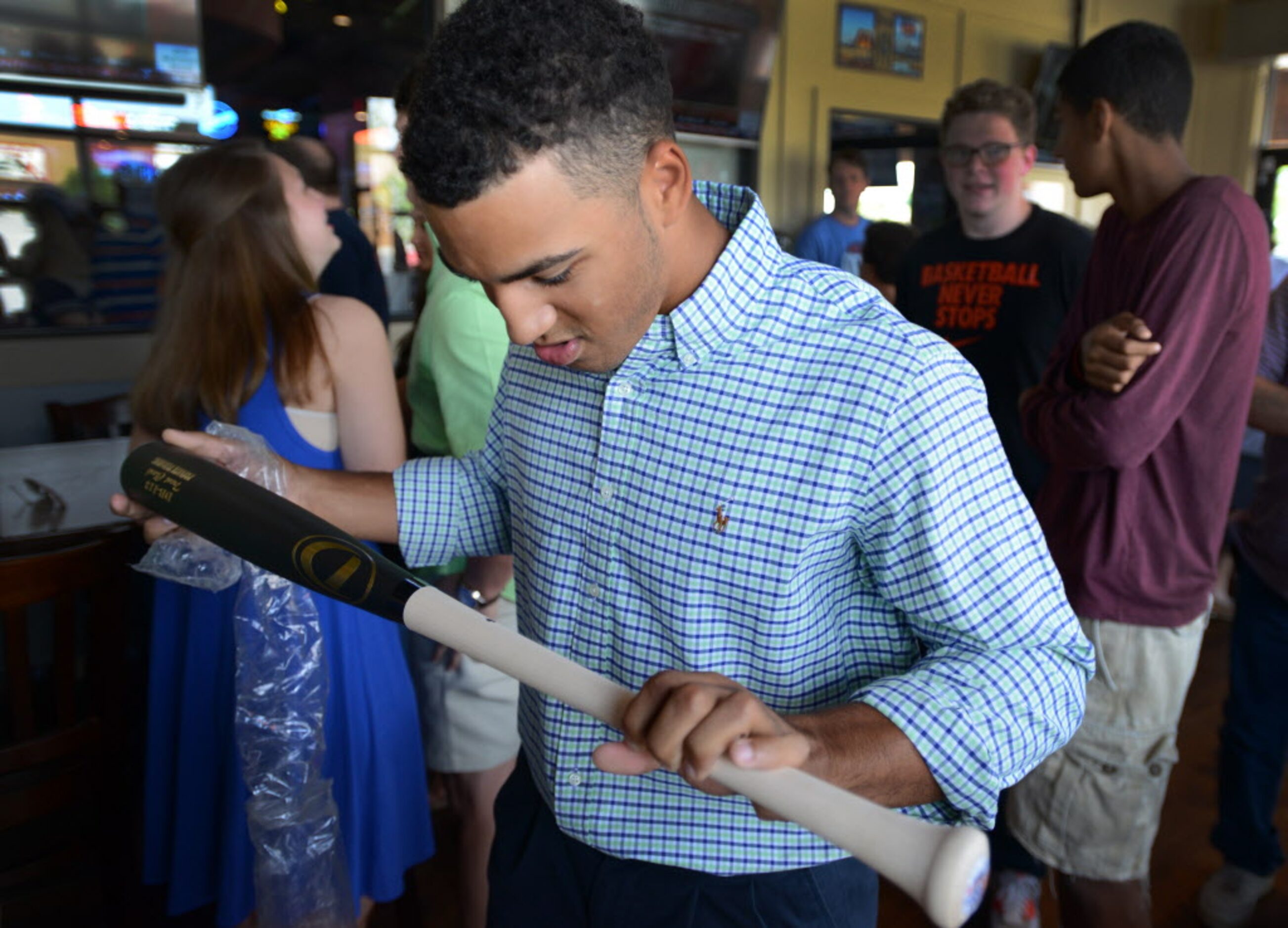 Trent Clark checks out a bat with his name carved in it prior to being chosen by the...