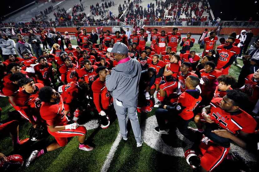 Cedar Hill High head football coach Carlos Lynn (center) huddles his players for a post-game...