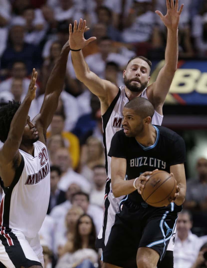 Charlotte Hornets guard Nicolas Batum looks for an open teammate past Miami Heat forward...