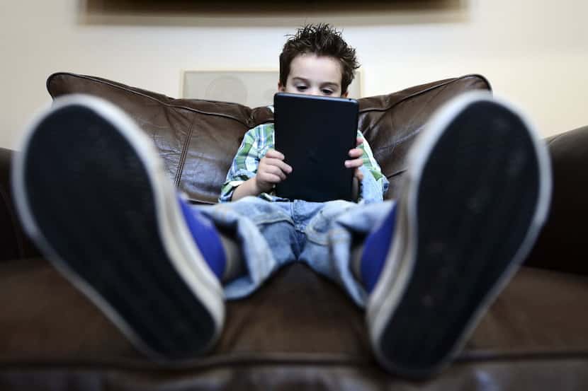 Maddon Segall, 3, plays on an iPad mini in his home in Livingston, N.J., Dec. 19, 2013....
