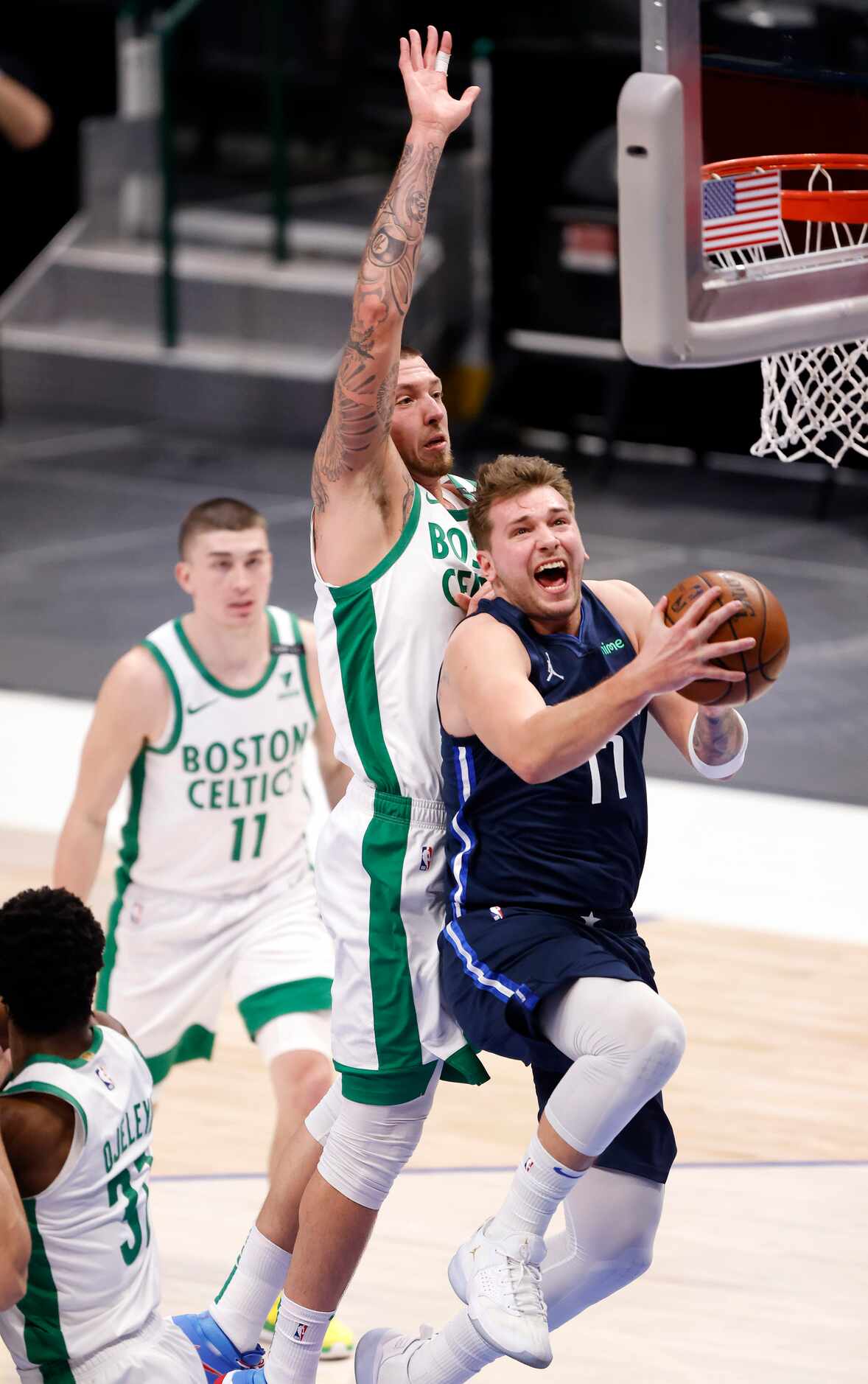 Dallas Mavericks guard Luka Doncic (77) drives to the basket as he's guarded by Boston...