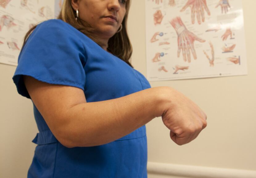 Brenda Alvarez demonstrates Step 4 of an arm exercise to alleviate hand pain.