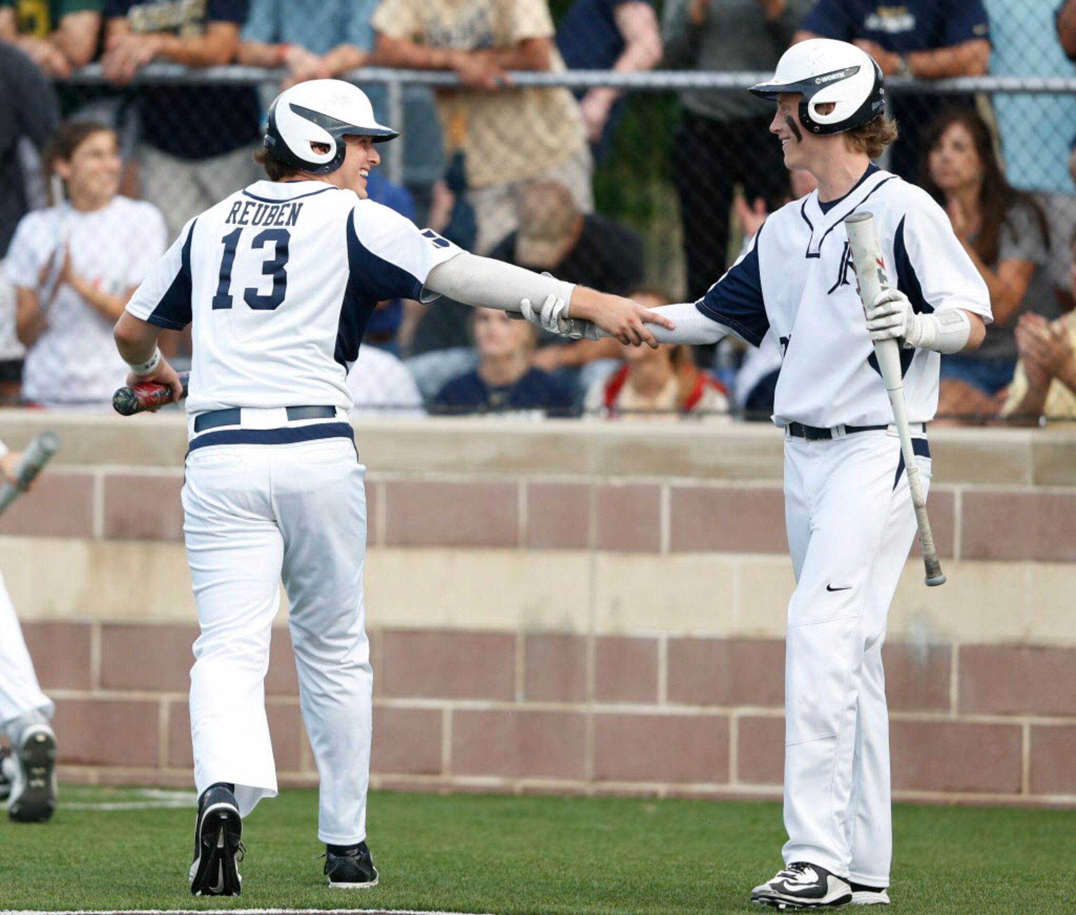 Jesuit's Grant Reuben (13) is congratulated by teammate Austin Sheahan (20) after scoring a...