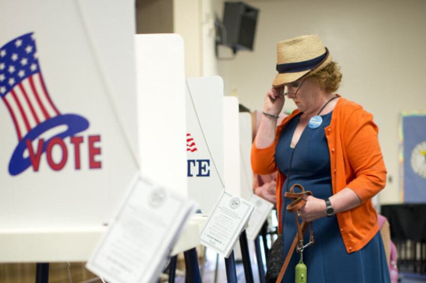 Deborah Murphy examines the ballot while voting at a polling station. AFP PHOTO / ROBYN...