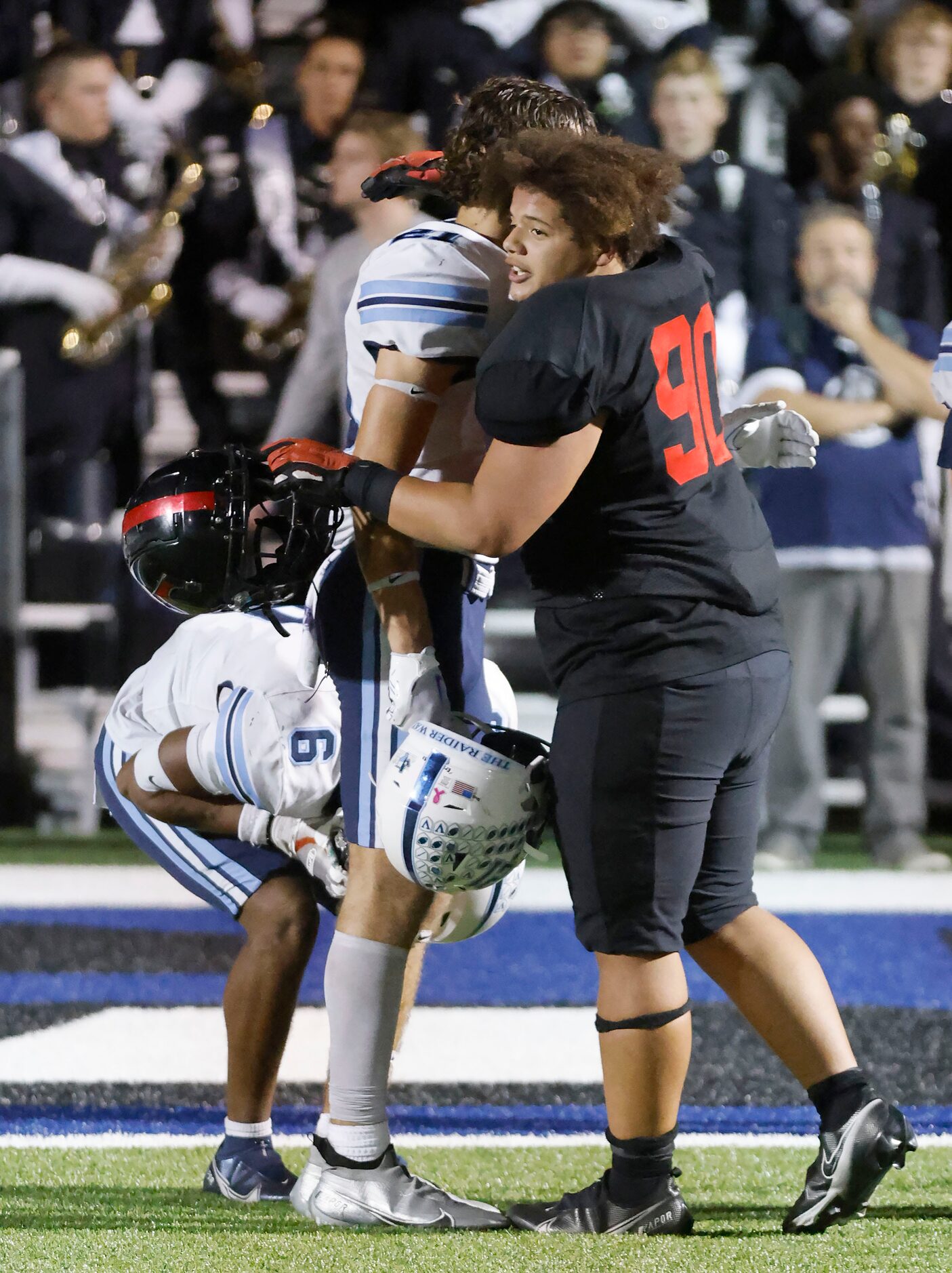 Euless Trinity defensive lineman Trevon Jones hugs Hurst L.D. Bell linebacker Mason Erickson...