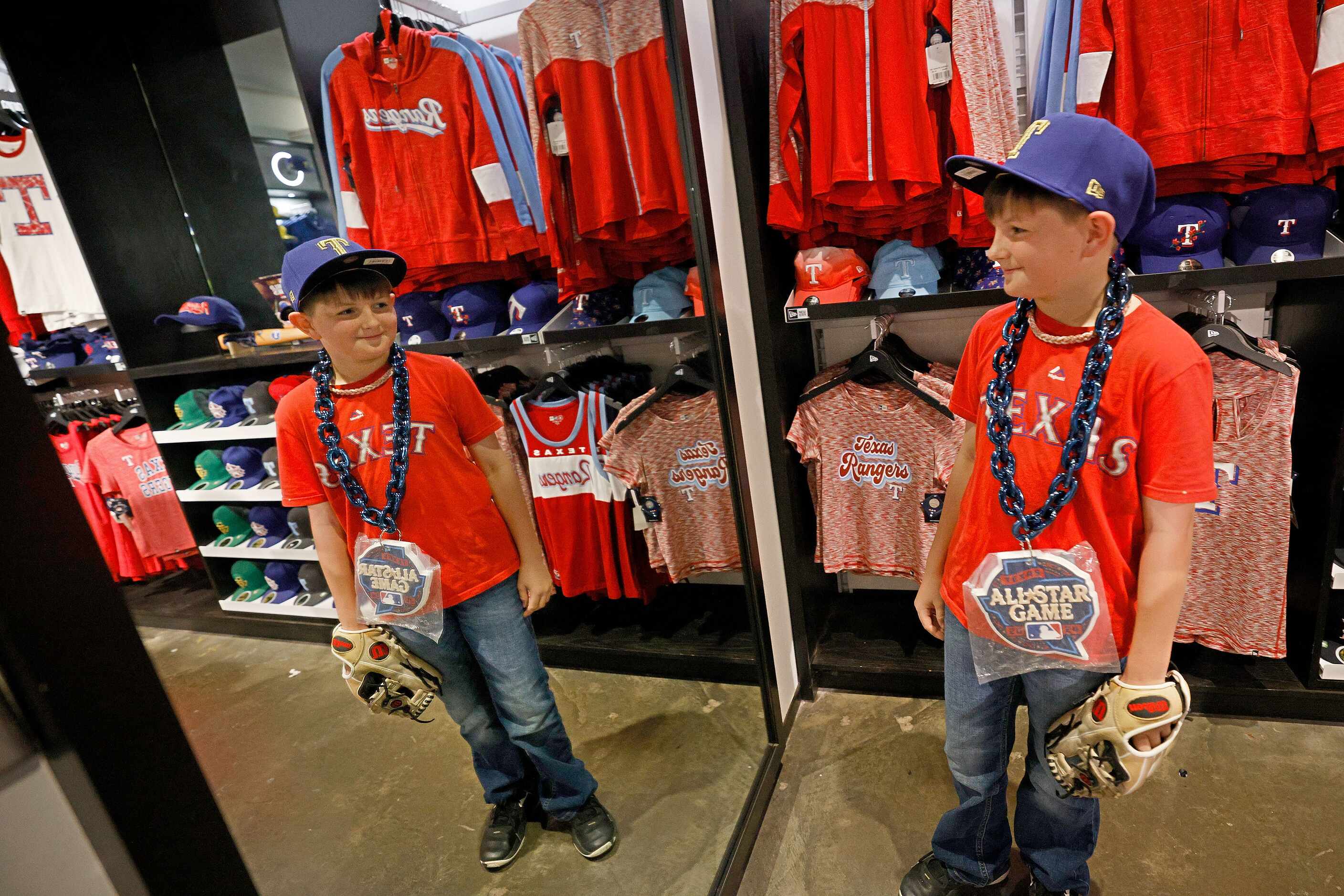 Texas Rangers fan Waylon Green, 10, of Ennis, Texas, checks himself in a mirror as he shops...