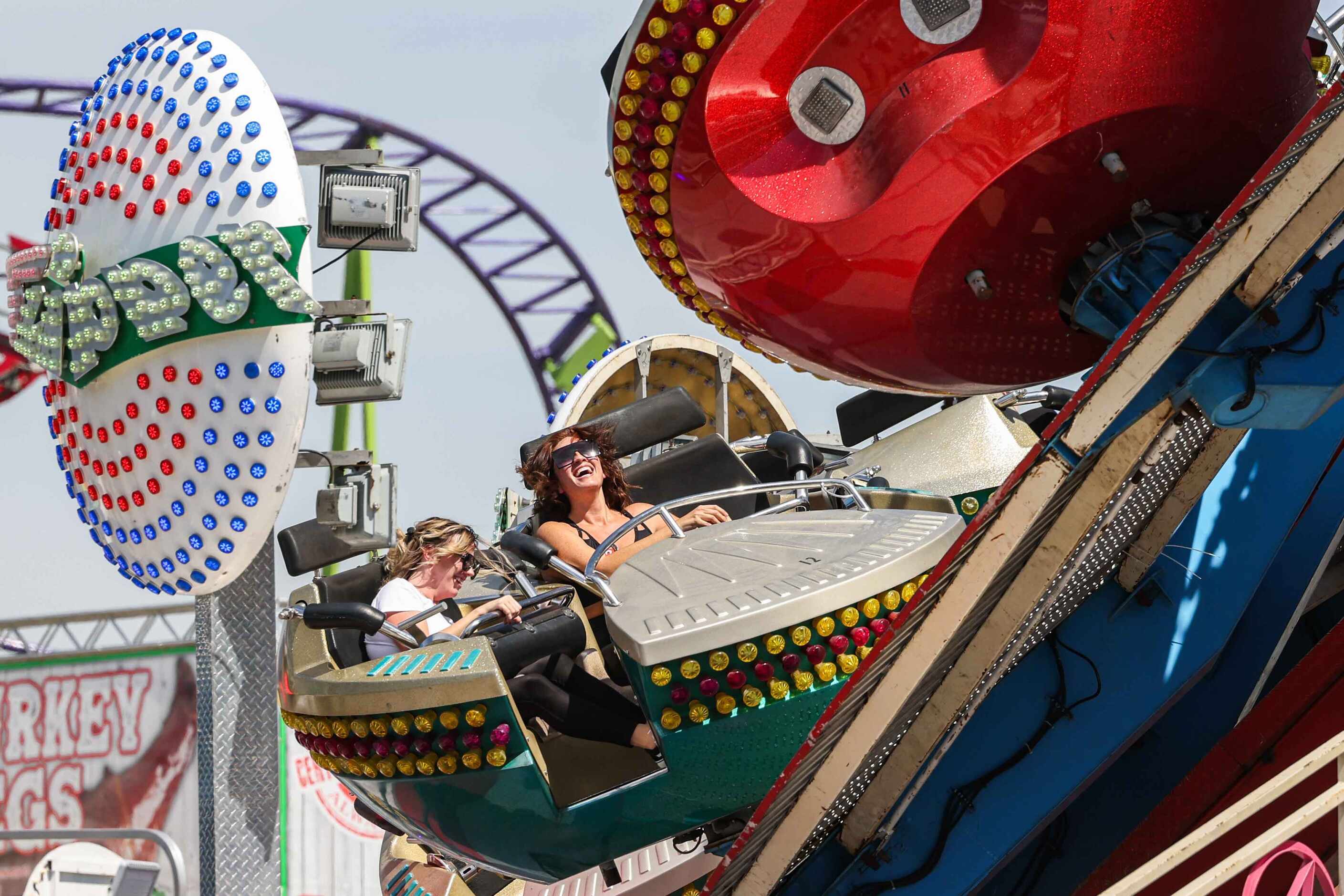 People aboard a carnival ride at the State Fair of Texas during its opening day in Dallas on...