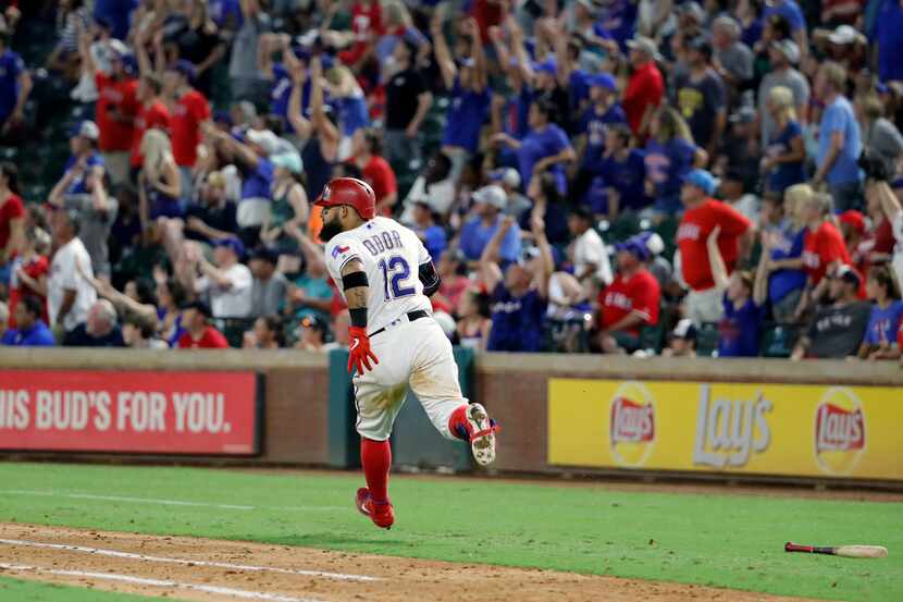 Fans stand and cheer as Texas Rangers' Rougned Odor rounds the bases after hitting a...