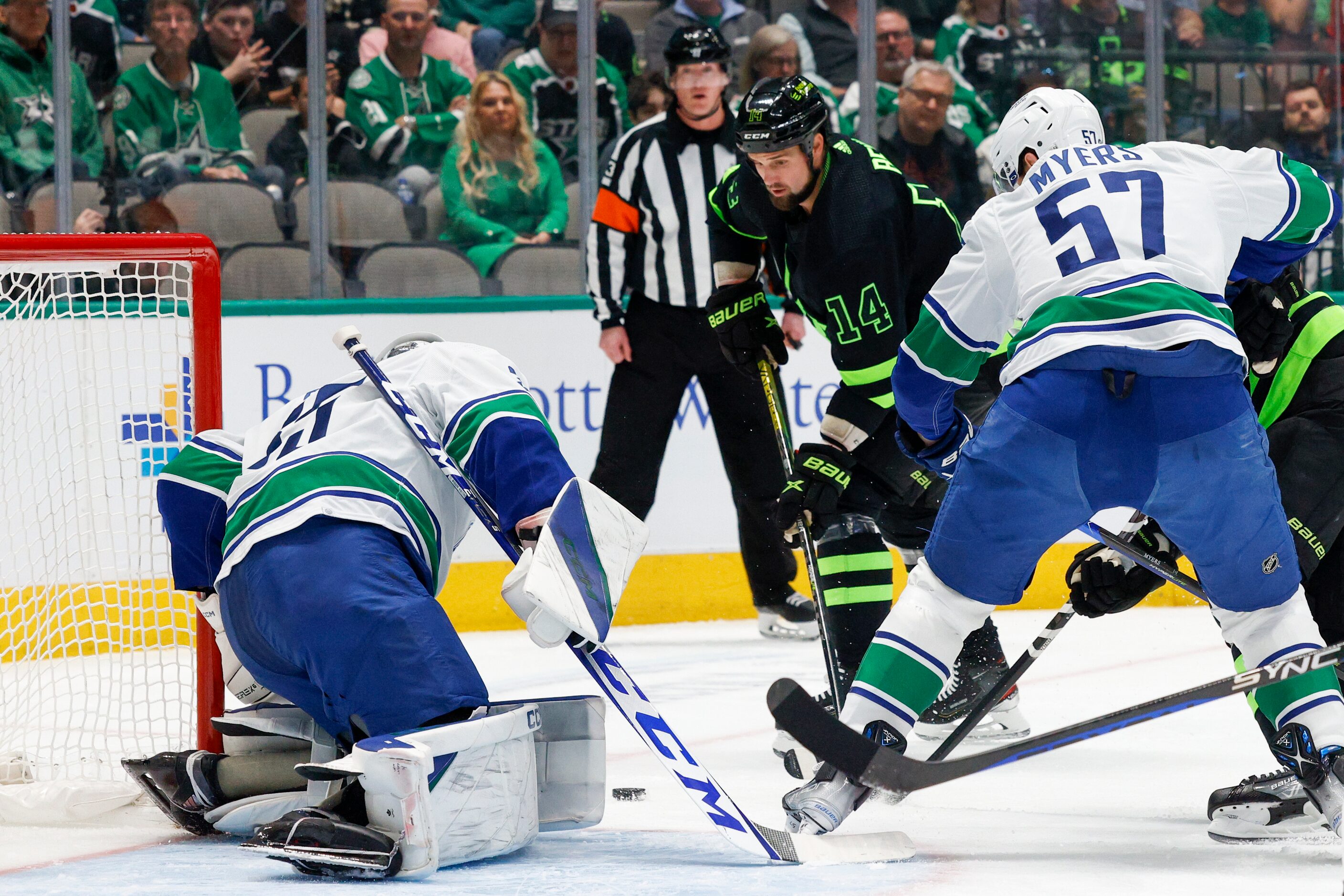 Dallas Stars left wing Jamie Benn (14) knocks a shot towards goal and Vancouver Canucks...