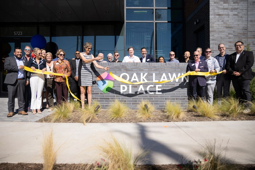 Cece Cox, CEO of Resource Center, holds the scissors as she cuts the ribbon during the grand...