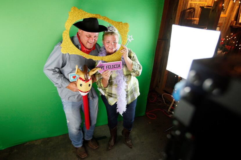 Cliff Farmer, 52, and Hope Farmer, 53, wear photo booth props while posing for pictures at...