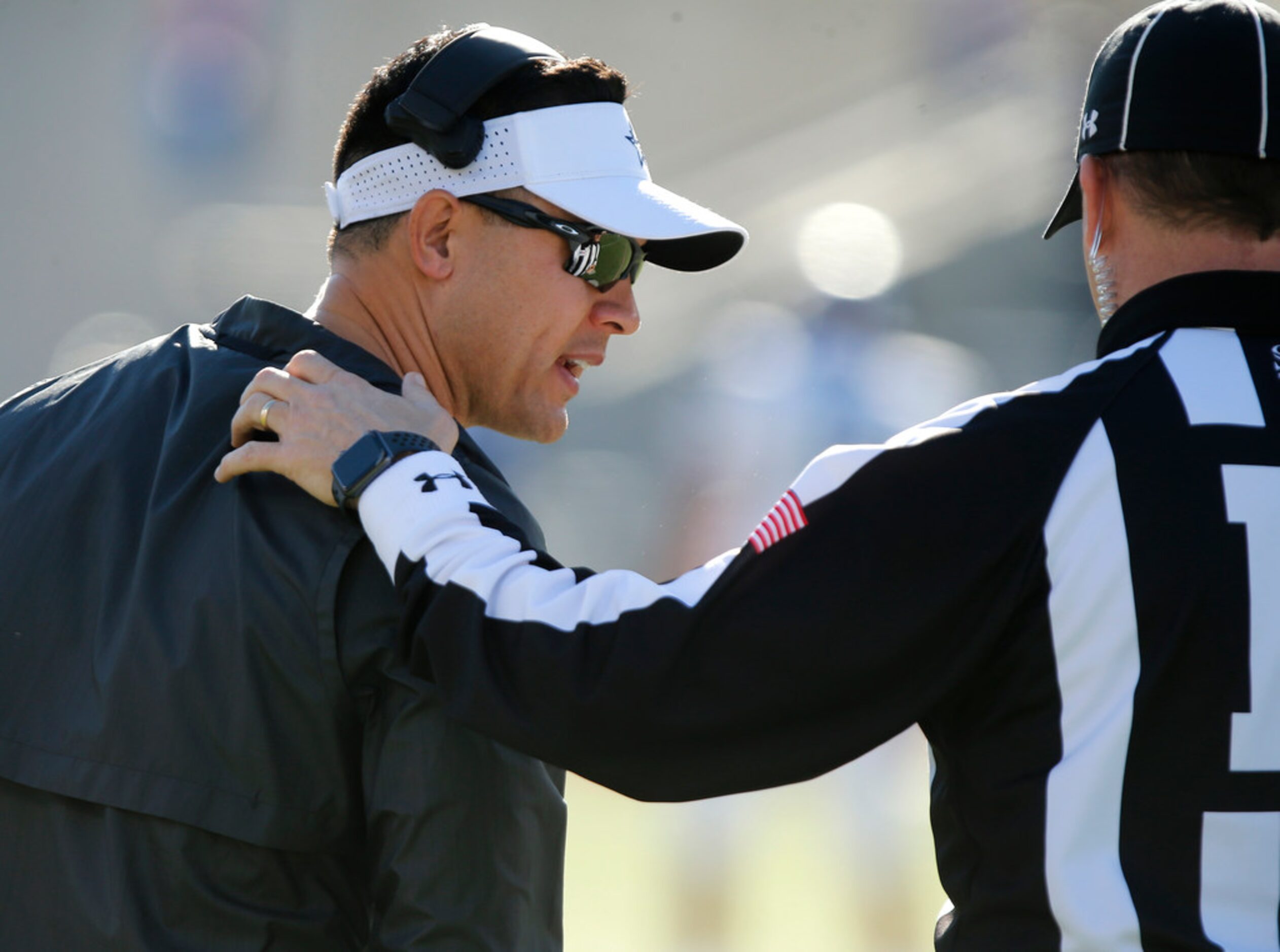 Lone Star High School head coach Jeff Rayburn talks with an official during the first half...