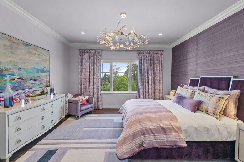 A teenager's room is designed with purple wallpaper, purple painted walls, and purple...