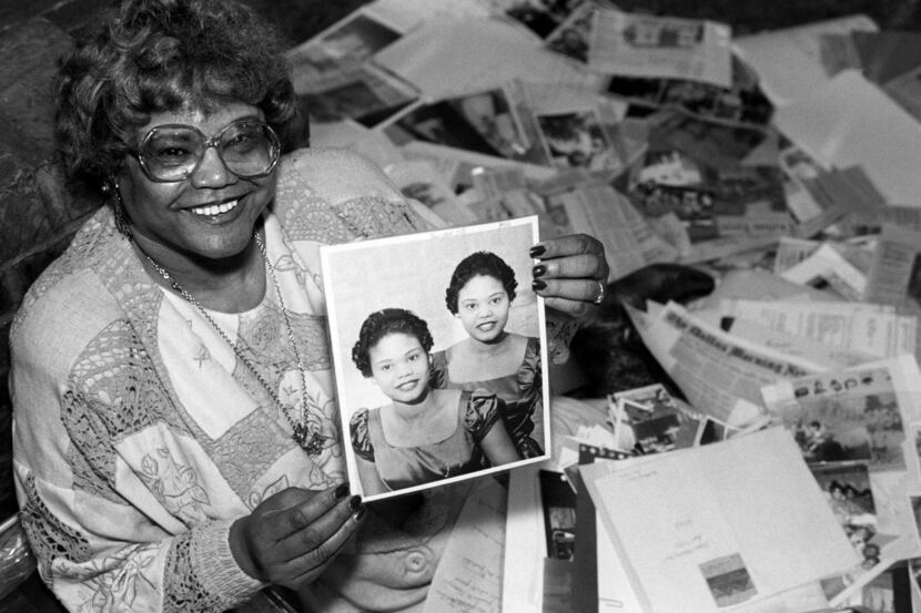 In this 1994 photo, Ina Bell Daniels McGee holds a picture from 1956 of her and her twin...