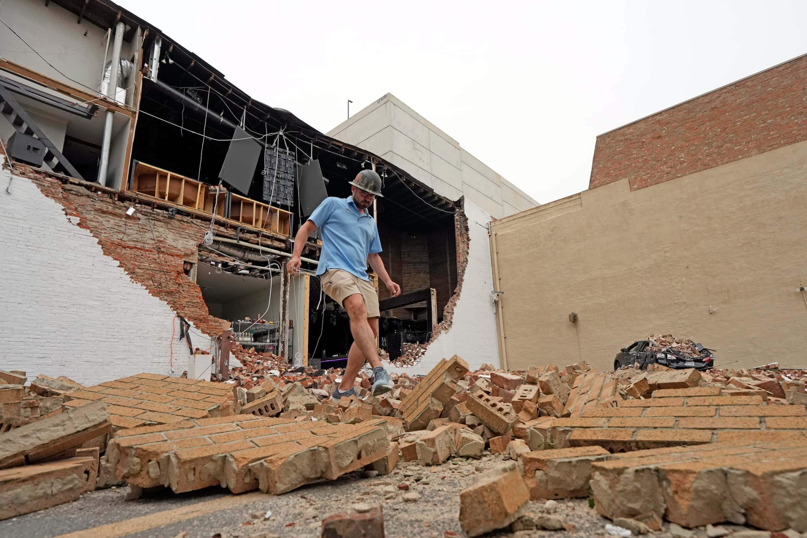 A man walks over fallen bricks from a damaged building in the aftermath of a severe...