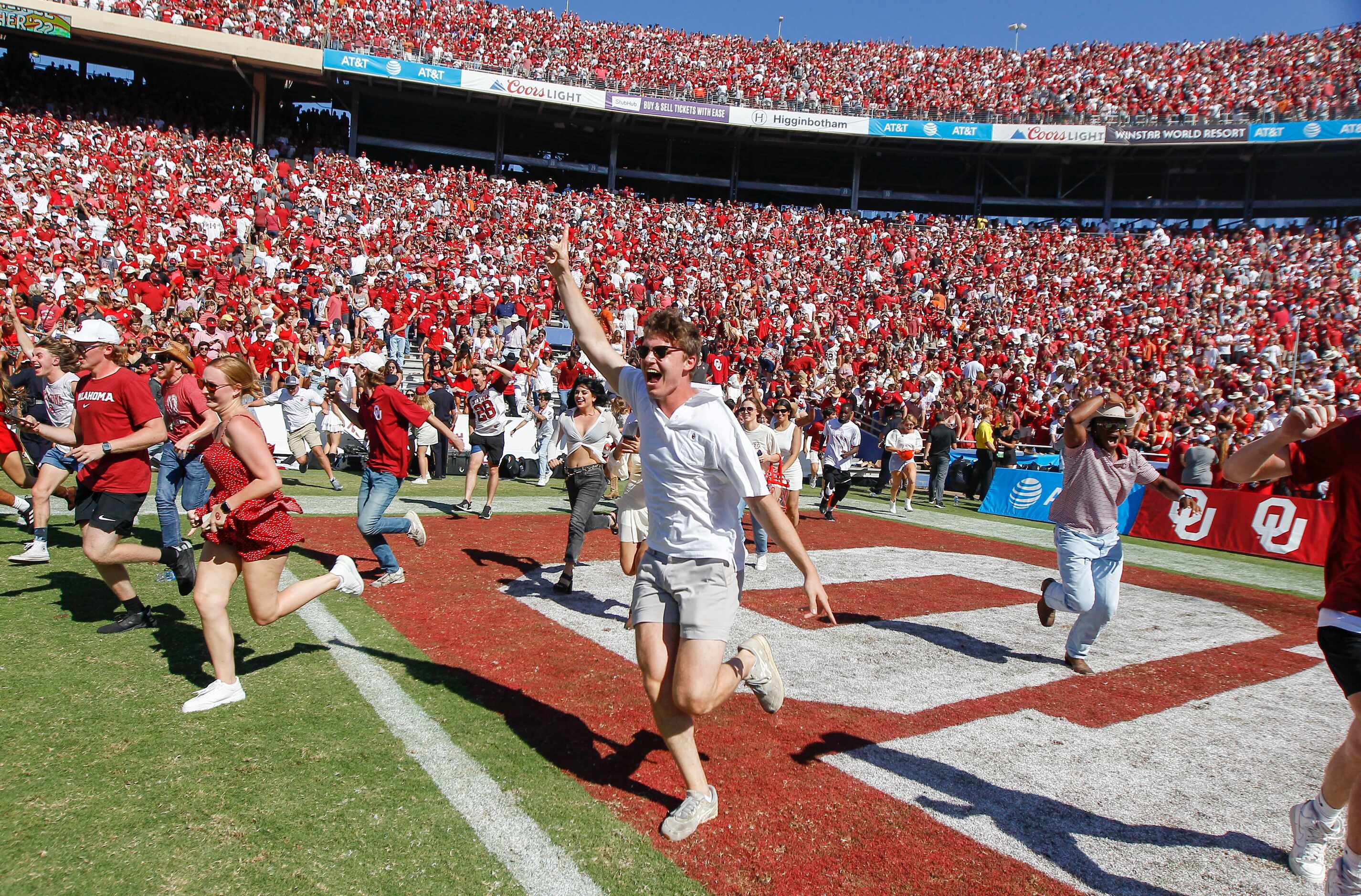 Oklahoma fans rush the field in celebration of a 55-48 come from behind win over Texas after...